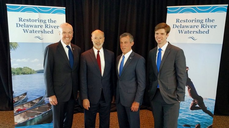 Governor Wolf and associates standing in front of Restoring the Delaware Watershed banners