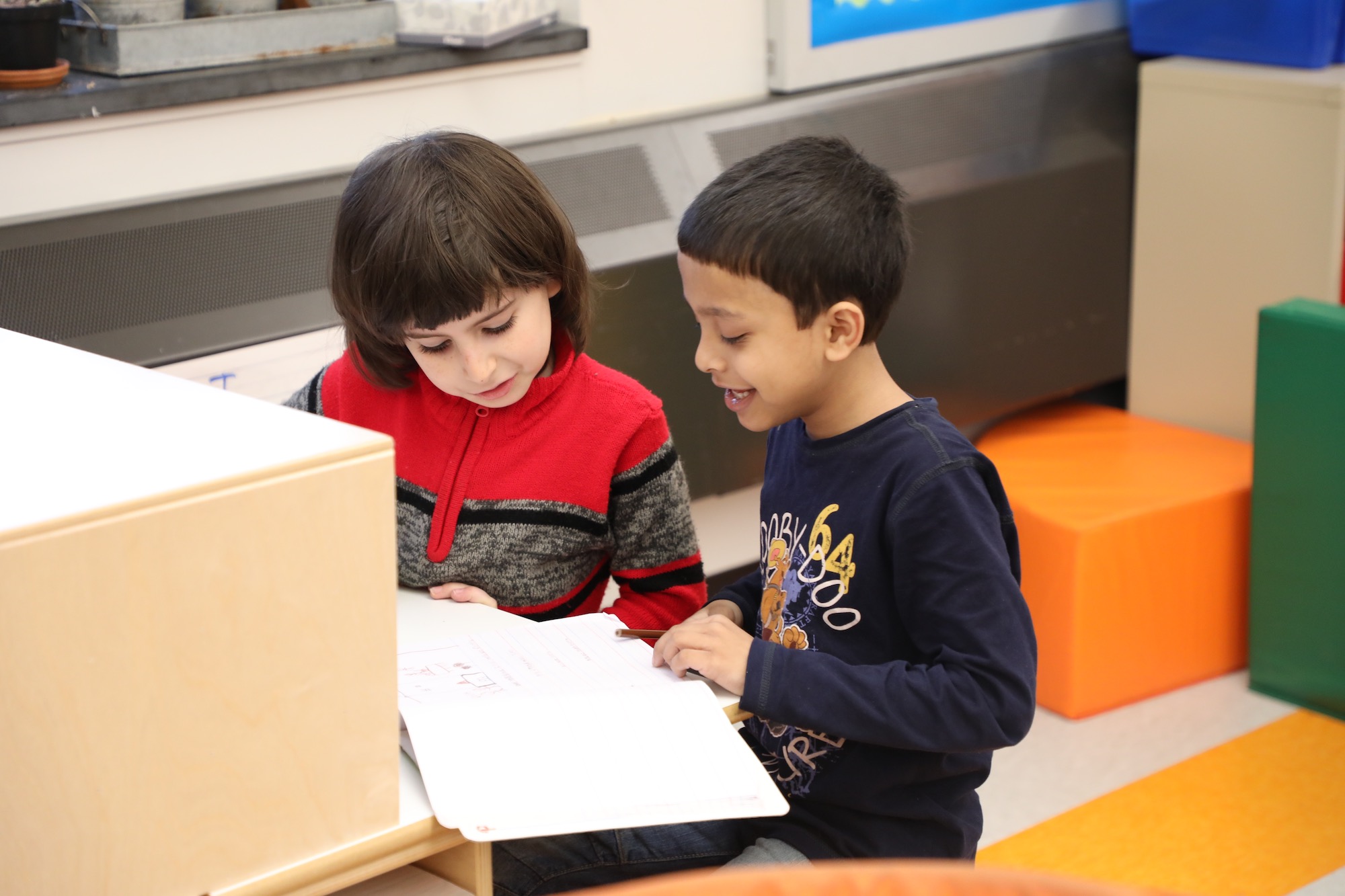 Two elementary school boys read next to each other.