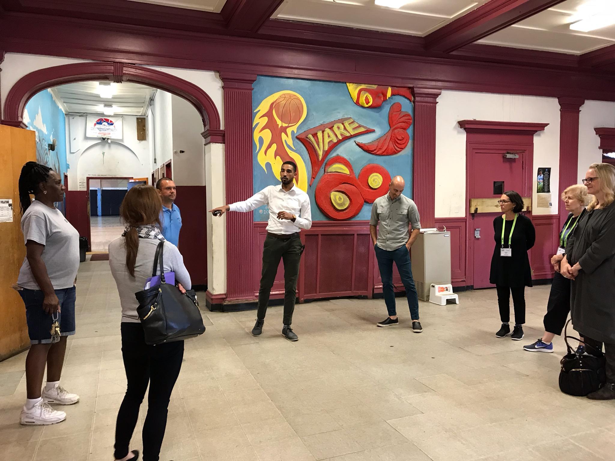 Group of adults standing in front of an indoor mural at Vare Recreation Center