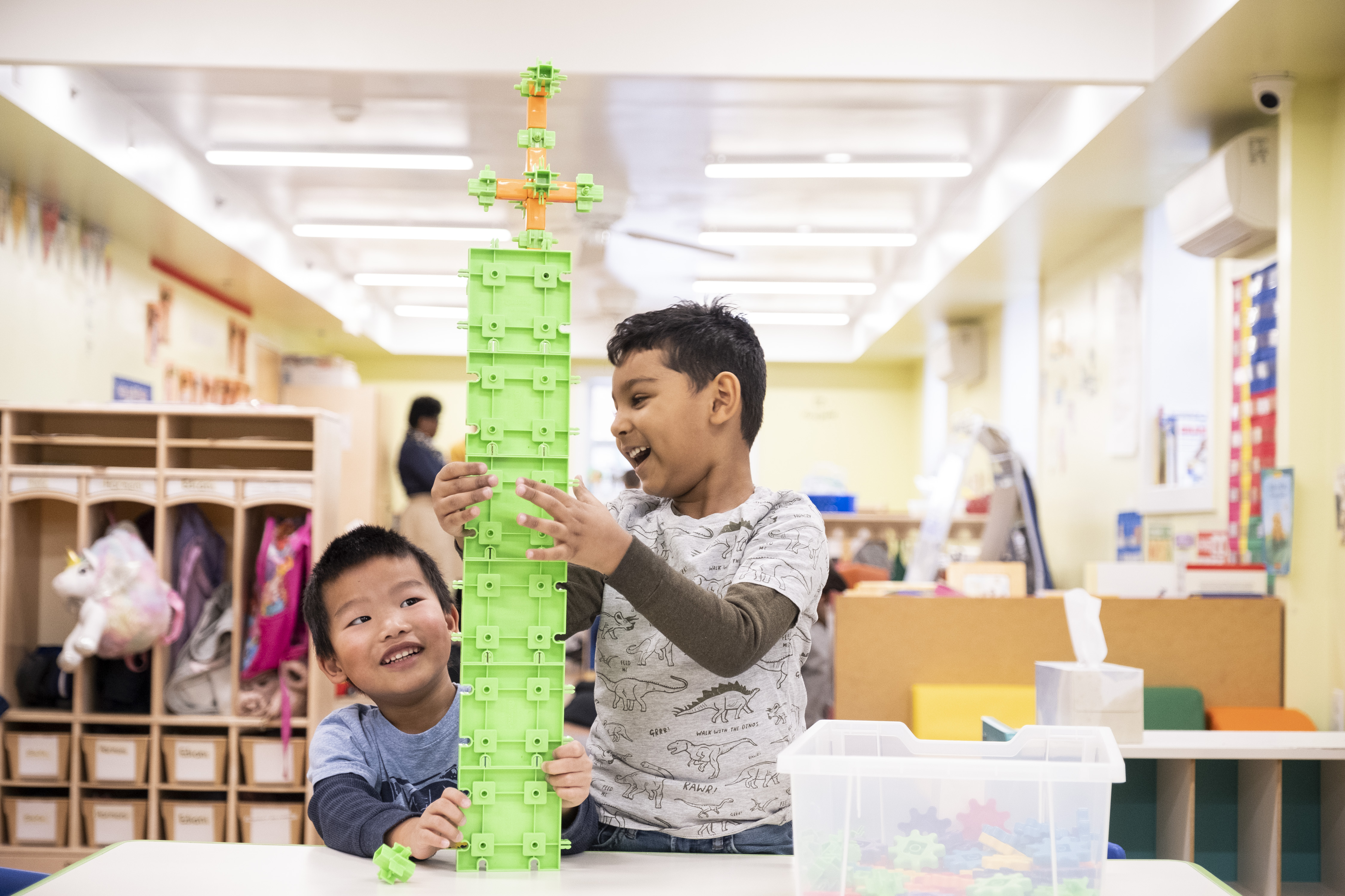 Two children have fun in the classroom with building blocks