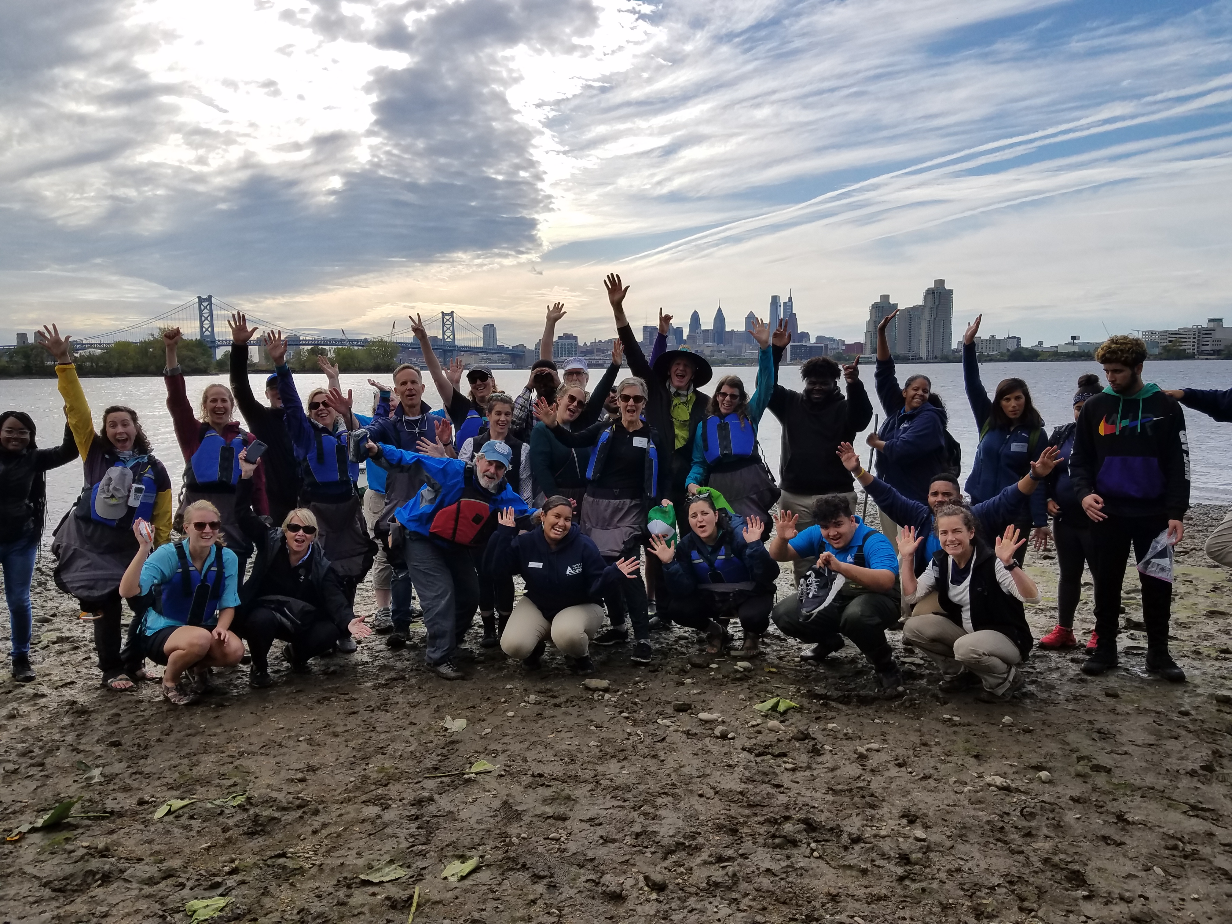 Blue Sky Funders group standing on banks of the Delaware River in Camden, New Jersey with downtown Philadelphia in distance