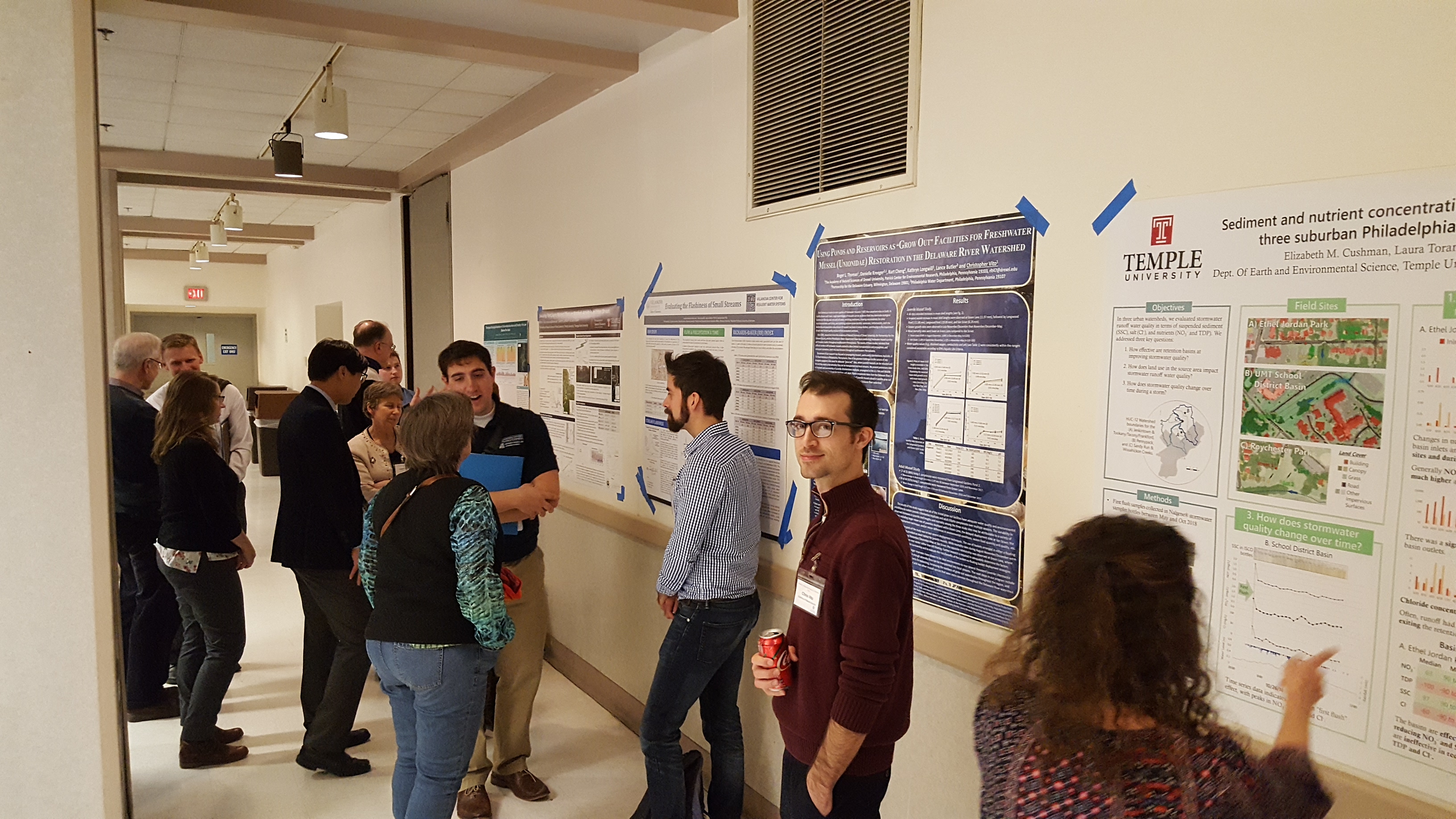 group of conference attendees in front of project boards