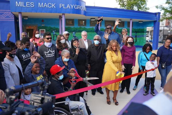 A crowd of people at a ribbon cutting ceremony at Miles Mack Playground.